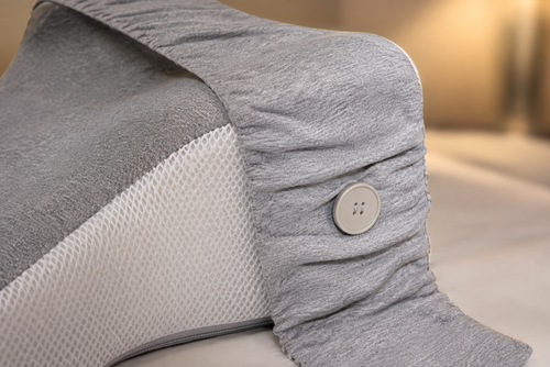 Close-up of the OrthoCore knee pillow showing the grey knit top and breathable mesh sides