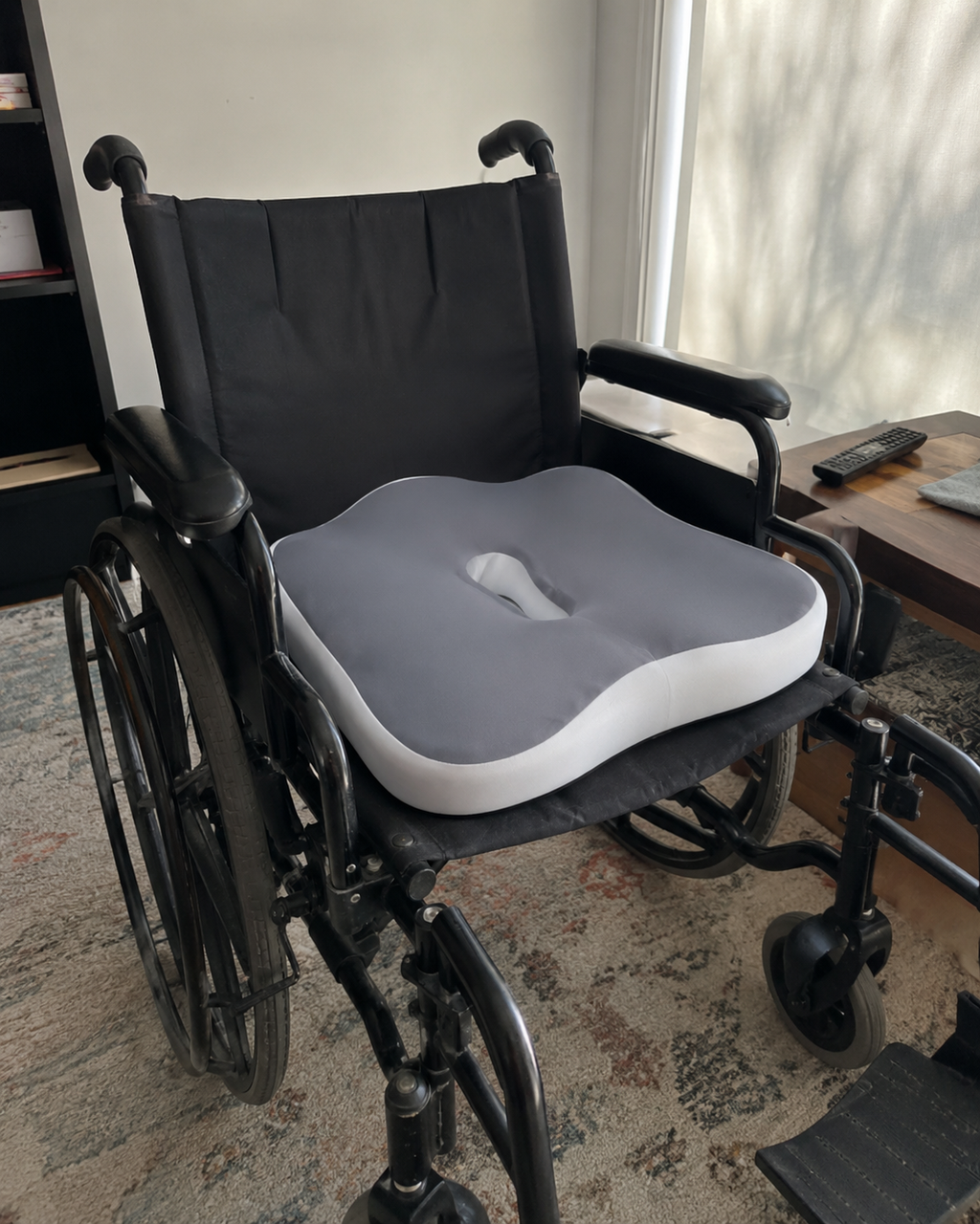 OrthoCore grey seat cushion fitted to a wheelchair seat in a bright room