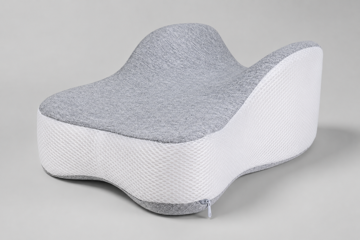 OrthoCore grey contoured memory foam knee pillow on a plain studio background